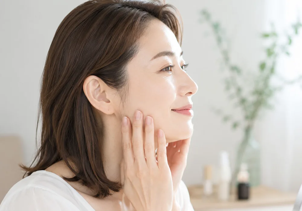 頬にやさしく手を添えて微笑む女性